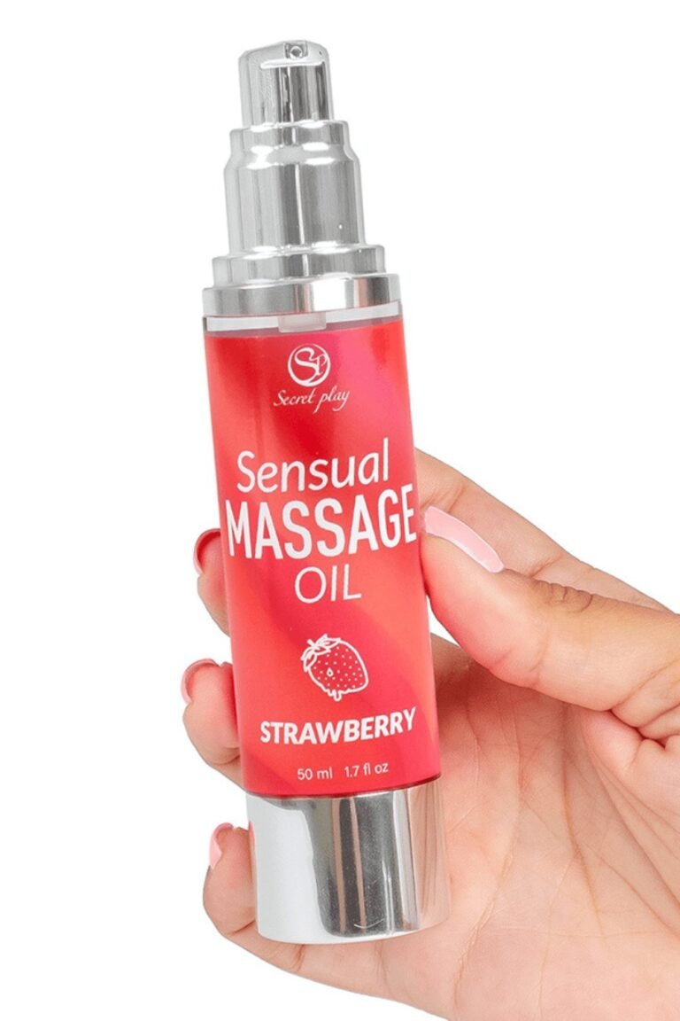 Main tenant un flacon d'huile de massage parfum fraise à pompe