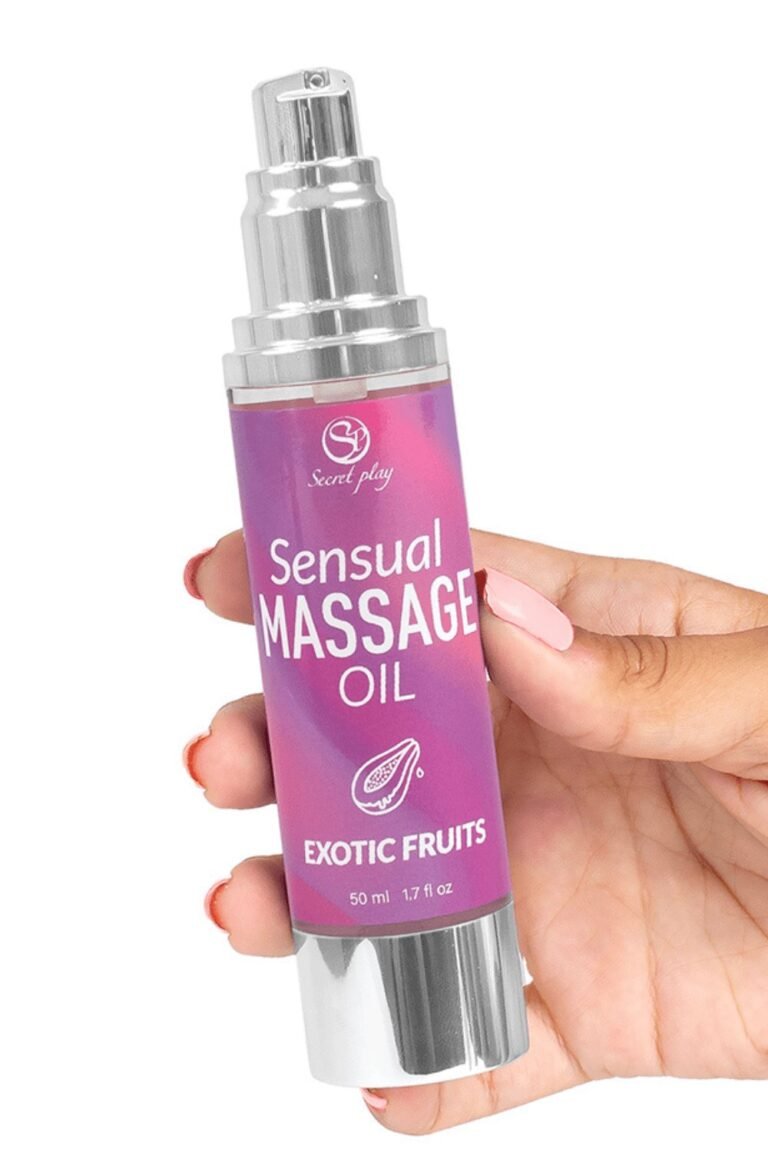Flacon d'huile de massage érotique aux fruits exotiques tenu en main