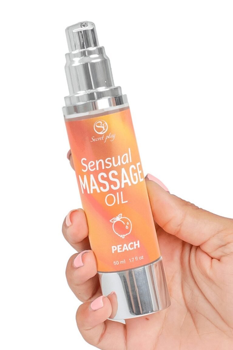 Huile de massage sensuelle parfum pêche tenue dans une main aux ongles roses