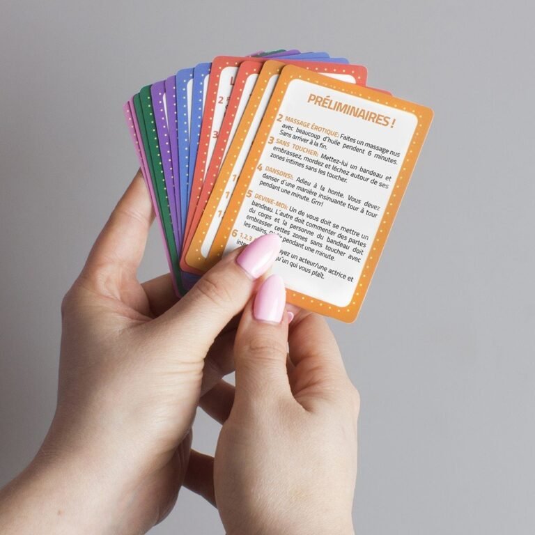 Mains tenant un éventail de cartes de défis préliminaires d'un jeu de gages pour couple