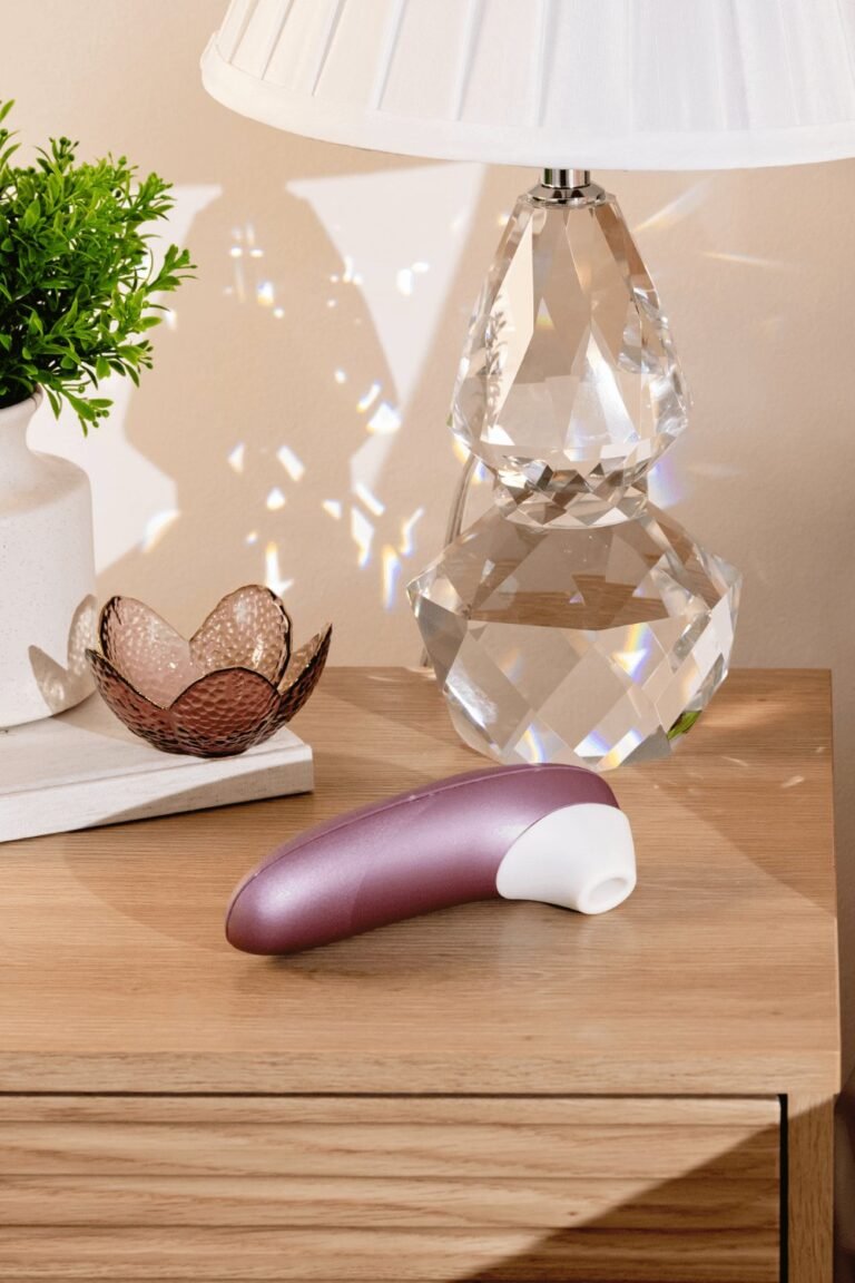 Stimulateur clitoris à air pulsé violet posé sur une table de chevet